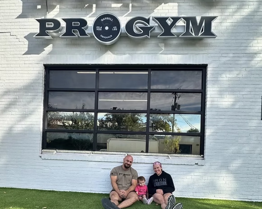 Delf's Pro Gym owners Hailey and Ryan Delf with their child outside the gym